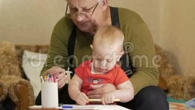 可爱的宝宝和他的祖父在纸上画着记号。 这孩子过敏，<strong>眼睛发红</strong>。 孩子一年。